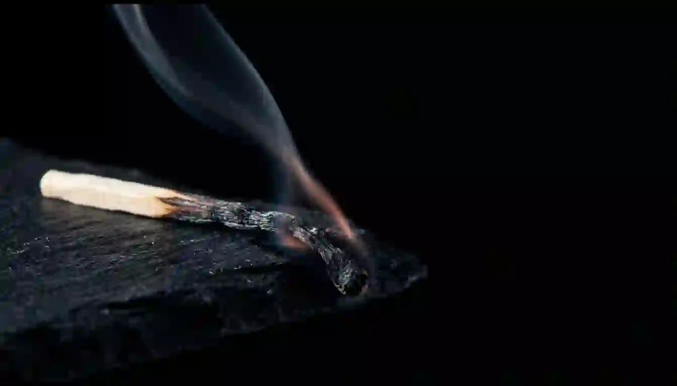 Un contacto quemado no se recupera: se apaga y ya no prende otra vez Cerilla de madera quemada y apagada sobre pizarra oscura, con un hilo de humo todavía subiendo